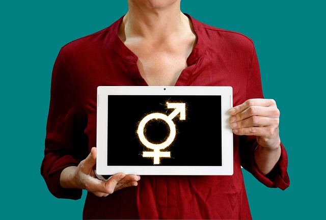 Image of a person holding a tablet with gender symbols, representing the rights and issues facing transgender West Virginia residents and how attorney M. Andrew Brison can help.